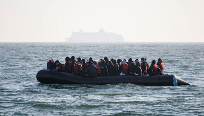 Migrants wait for help from French ship after their boats generator broke down in French waters while trying to cross the Channel illegally to Britain, off the coasts of Boulogne-sur-Mer, northern France, on May 9, 2022. — AFP