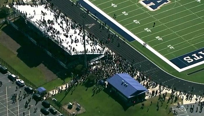 Students and staff gather next to the football field after law enforcement officers responded to a fatal shooting at Apalachee High School in a still image from aerial video in Winder, Georgia on September 4. — Reuters