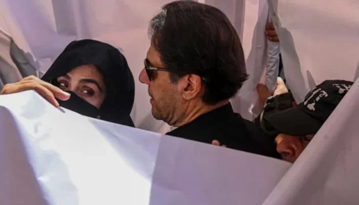 PTI founder Imran Khan and his wife, Bushra Bibi ahead of a court hearing. — AFP/File