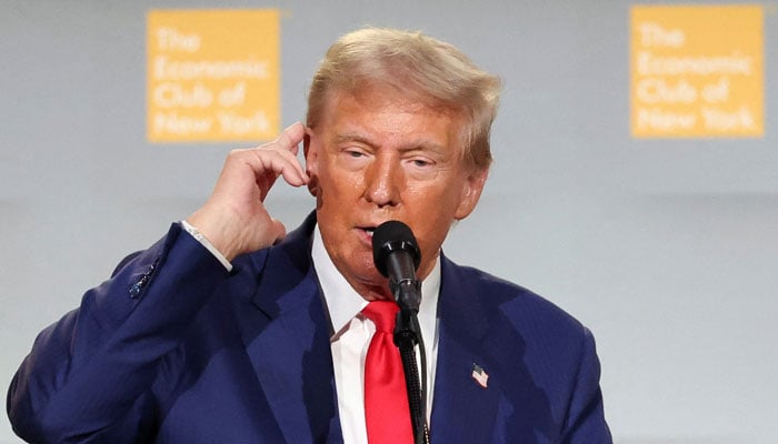 Republican presidential nominee and former US President Donald Trump points to his ear as he speaks at the Economic Club of New York in New York City, US September 5, 2024. — Reuters