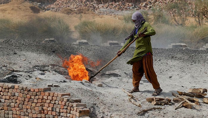 A labourer works at a brick kiln during a hot summer day on the outskirts of Larkana on May 23, 2024. — Reuters