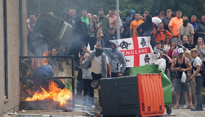 Demonstrators toss a trash bin during an anti-immigration protest, in Rotherham, Britain, August 4, 2024. — Reuters