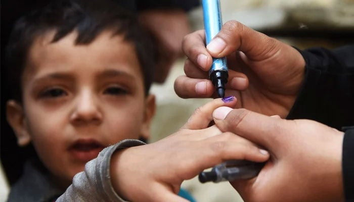 Representational image of a child being marked vaccinated by a health worker after inoculation against poliovirus during a door-to-door immunisation campaign in Karachi. — AFP/File