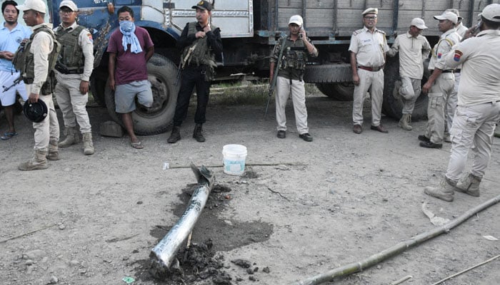 Police personnel and locals stand near the remains of a missile after it struck in Moirang, Manipur, India, September 6, 2024. — Reuters