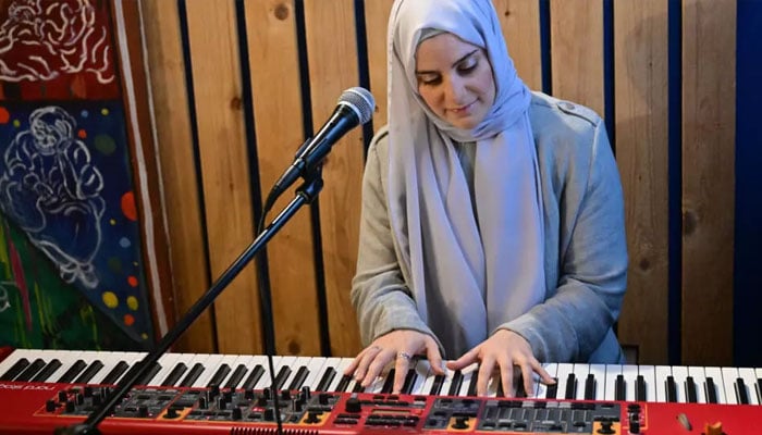 Syrian singer Ghalia Chaker plays a keyboard. — AFP/File