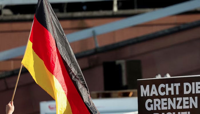 A person holds a poster reading: Close the borders during a right wing Alternative for Germany (AfD) party protest, one week after a man killed a policeman with a knife in the city of Mannheim, Germany, June 7, 2024. — Reuters