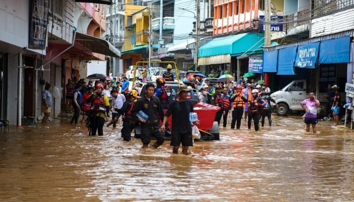 Rescue workers help stranded people from a flooded area at the border town of Mae Sai, Chiang Rai, on September 11. —Reuters