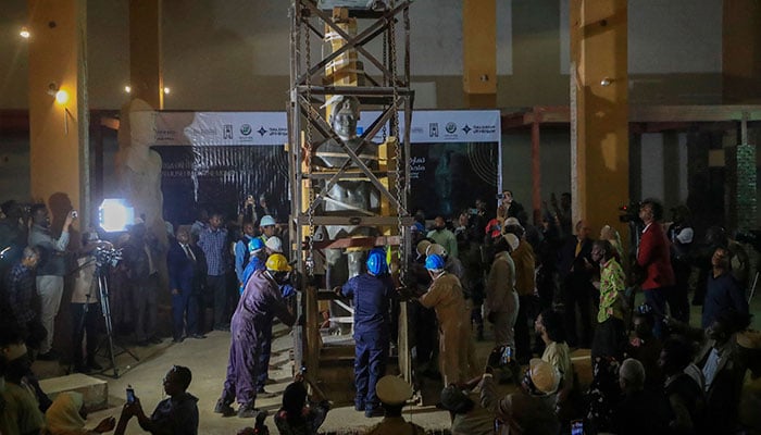 Workers move the 7th century BC statue of King Taharqa, of the 25th dynasty of the Kushite Empire, from the entrance of the National Museum of Sudan to a new location inside, as part of ongoing renovations of the museum, in Khartoum on January 14, 2023. — AFP