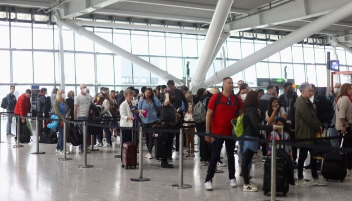 Passengers queue to enter airport security ahead of the Easter Bank Holiday weekend, at Terminal 5 of Heathrow Airport, in London, Britain, on April 14, 2022. —Reuters