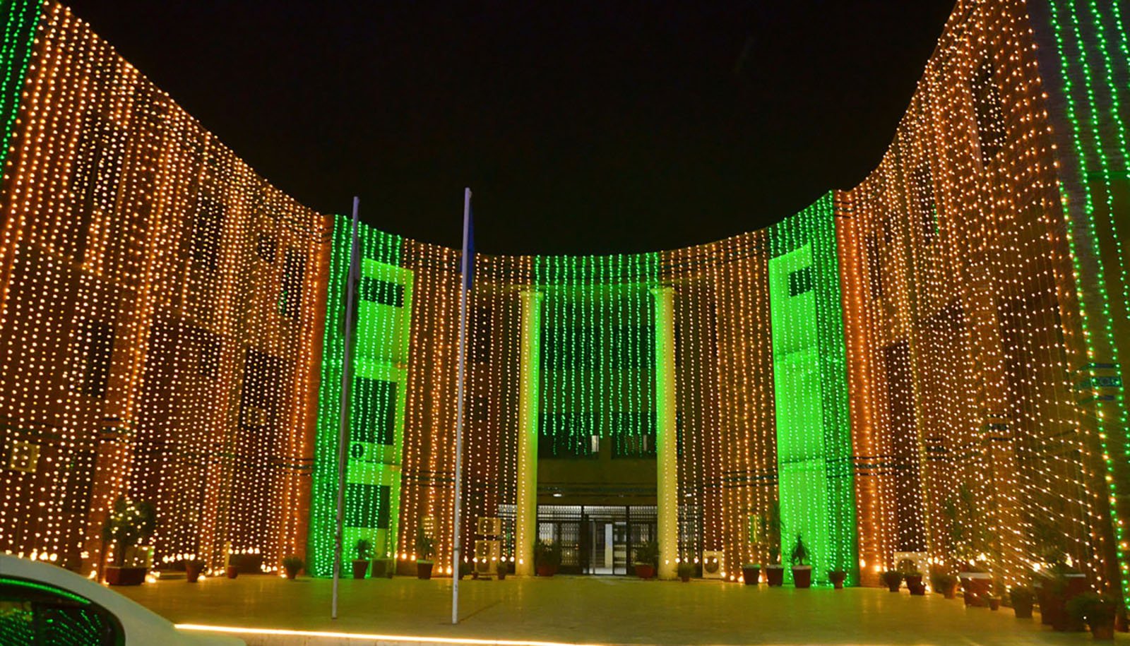 A building illuminated with green and red lights in Faisalabad on September 16, 2024.  — Online