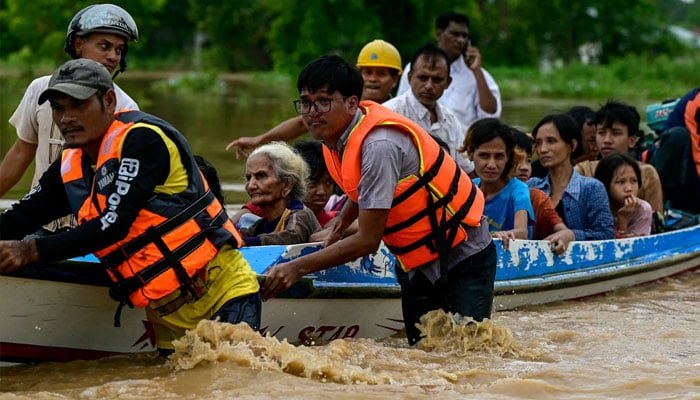 Flood-affected residents are transported on a rescue boat in Taungoo, Myanmars Bago region on September 14, 2024, following heavy rains in the aftermath of Typhoon Yagi. — AFP