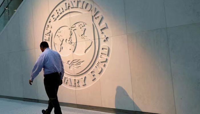 A man walks past the International Monetary Fund (IMF) logo at its headquarters in Washington, US, May 10, 2018. — Reuters