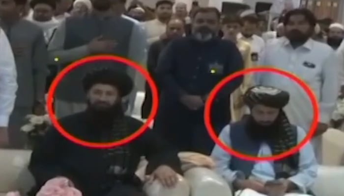 Afghan Acting Consul General Peshawar Hafiz Mohibullah Shakir (left) is seen sitting during Pakistani national anthem at a conference in Peshawar. — Screengrab via Geo News