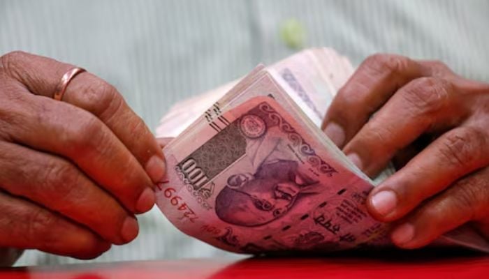 A man counts Indian currency notes inside a shop in Mumbai, India on August 13, 2018. — Reuters