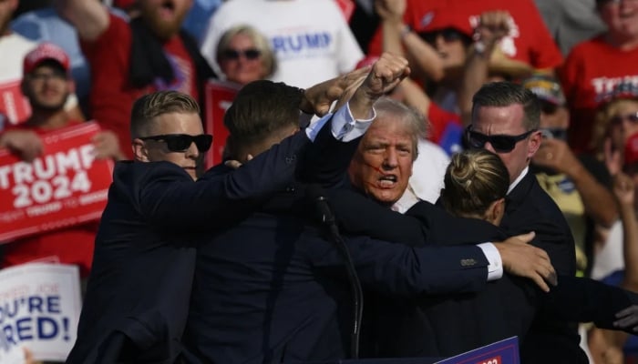 Republican presidential candidate, former US president Donald Trump is whisked away by Secret Service after shots rang out at a campaign rally at Butler Farm Show on July 13, 2024 in Butler, Pennsylvania. AFP