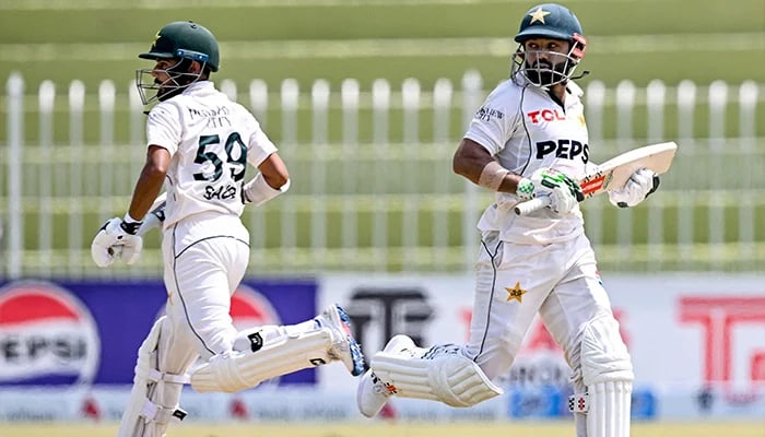 Pakistans Mohammad Rizwan (R) and Saud Shakeel run between the wickets during the second day of the first Test cricket match, Pakistan vs Bangladesh, Rawalpindi Cricket Stadium, August 22, 2024. — AFP