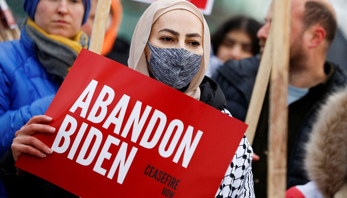 A Muslim woman stands with a Abandon Biden, Ceasefire Now sign during a protest calling for Biden administration to push for a permanent ceasefire in Gaza and condition aid to Israel. — X/@Reuters