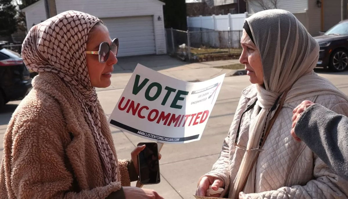 A Muslim organiser talks to voters outside of a polling location at Maples Elementary School in Dearborn, Michigan, on 27 February, 2024. — AFP