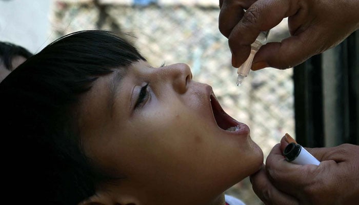 A health worker administrates polio-vaccine drops to a child during anti-polio immunization campaign in Azizabad area in Karachi on June 4, 2024. — PPI