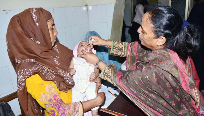 A lady health worker administering polio drops to a child during an anti polio campaign in Hyderabad on June 3, 2024. — APP