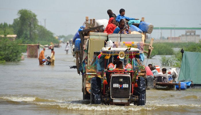 A family puts their belongings on a higher ground as they travel, following rains and floods during the monsoon season in Sohbatpur, Pakistan August 29, 2022. — Reuters