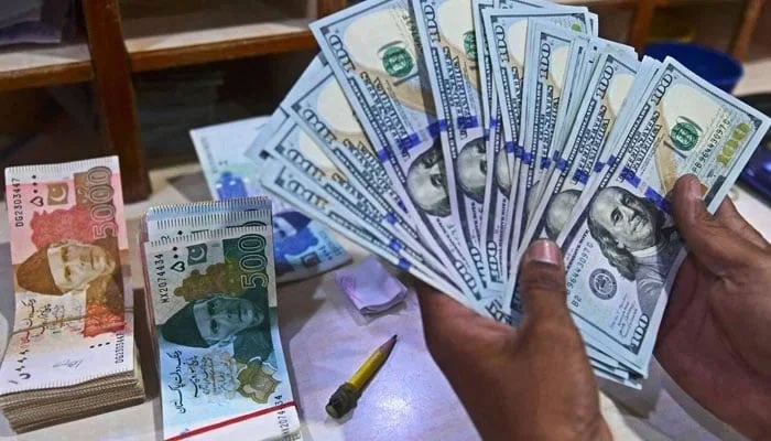 A foreign currency dealer counts US dollars at a shop in Karachi on May 19, 2022. — AFP