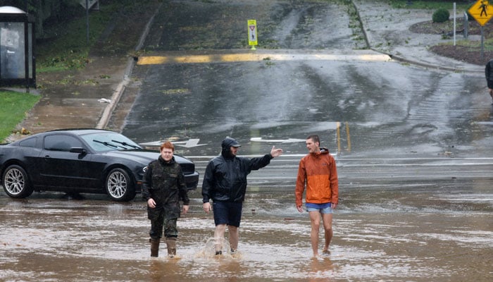 Pedestrians walk through a flooded street as Tropical Storm Helene strikes, in Boone, North Carolina, US September 27, 2024. — Reuters