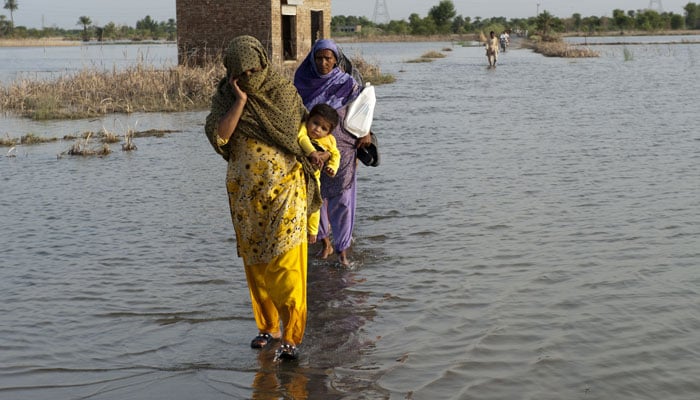 A representational image showing a family crossing a flooded street. — ADB/File