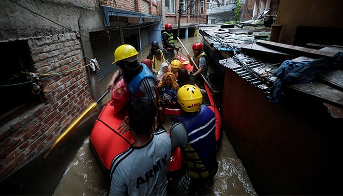 Security force members use an inflatable raft to bring residents to safety from a flooded area near the bank of the overflowing Bagmati River following heavy rains, in Kathmandu, Nepal on September 28, 2024. — Reuters