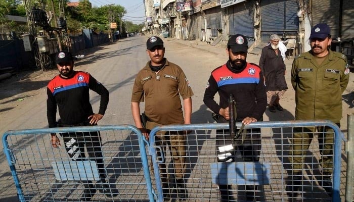 Police officials stand alert at Barf Khana Chowk on Railway Road in Lahore on April 21, 2024. —APP