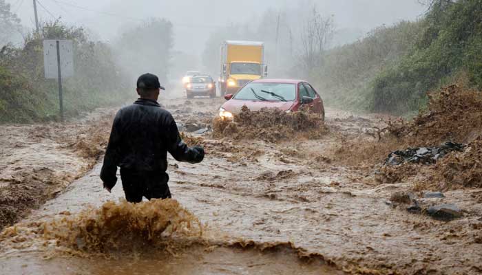 A local resident walks out into fast-flowing waters to assist a stranded driver in a stretch of flooded road as Tropical Storm Helene strikes, on the outskirts of Boone, North Carolina, September 27. — Reuters