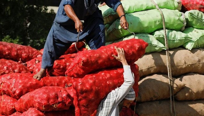 Labourers unload sacks of onion from a truck to supply at a market in Karachi, Pakistan February 1, 2023.— Reuters