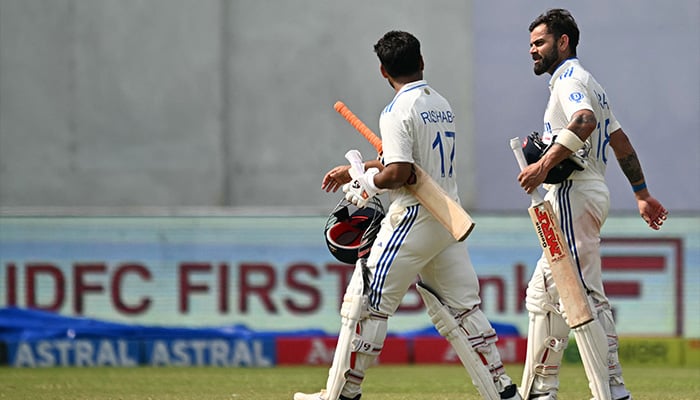 Indias Virat Kohli (R) and teammate Rishabh Pant walk back to the pavilion after winning the fifth and final day of the second Test cricket match between India and Bangladesh at the Green Park Cricket Stadium in Kanpur on October 1, 2024. — AFP