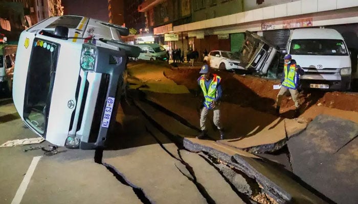 Police officers inspect damaged cars and road after a suspected gas explosion in the central business district of Johannesburg, South Africa on July 19, 2023. — Reuters