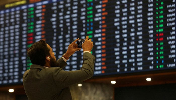 A broker takes a picture of a trading screen at the Pakistan Stock Exchange. — Reuters/File