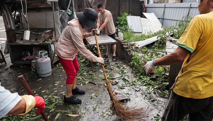 Staff clean up debris from a store after Typhoon Krathon made landfall in Kaohsiung, Taiwan October 4, 2024. — Reuters