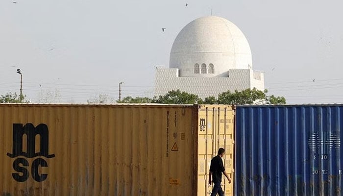 A man passes by containers placed near Mazar-e-Quaid in Karachi. — Reuters/File