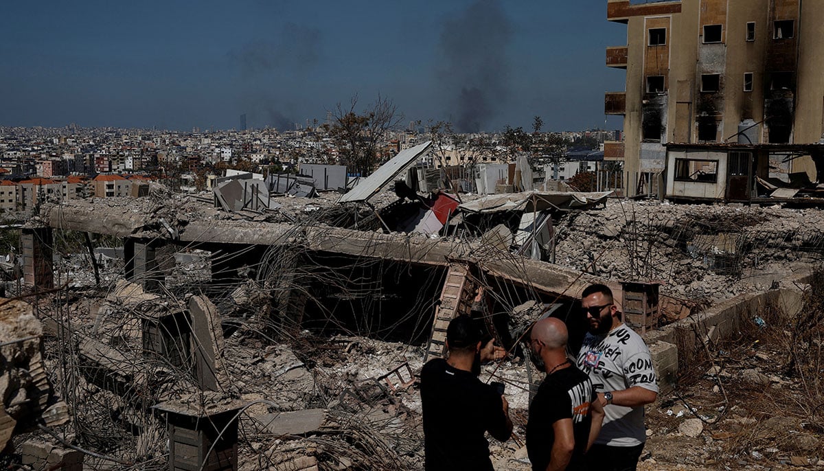 People stand amid damage caused by Israeli airstrikes, as smoke rises over Beirut southern suburbs, amid ongoing hostilities between Hezbollah and Israeli forces, in the Choueifat district, in Beirut, Lebanon, October 3, 2024. — Reuters