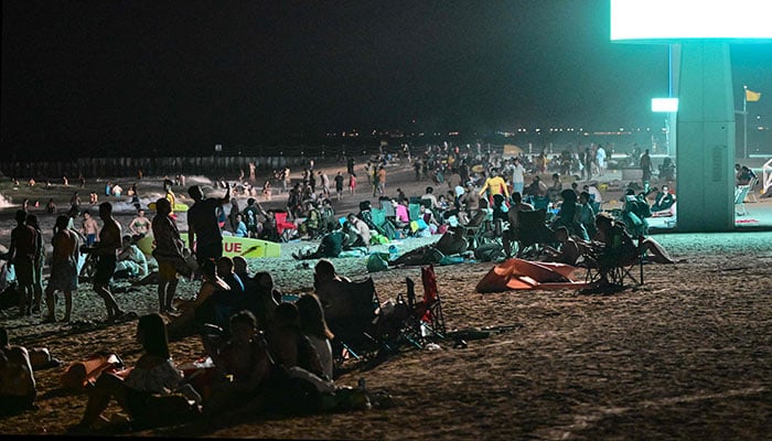 People gather at the Umm Suqeim beach in Dubai during the night of October 5, 2024. — AFP