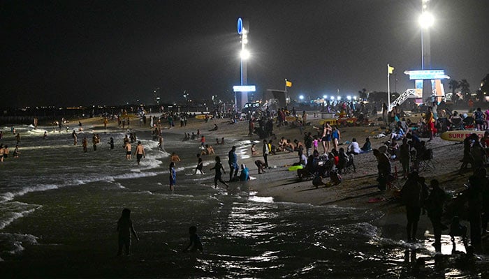 People gather at the Umm Suqeim beach in Dubai during the night of October 5, 2024. — AFP