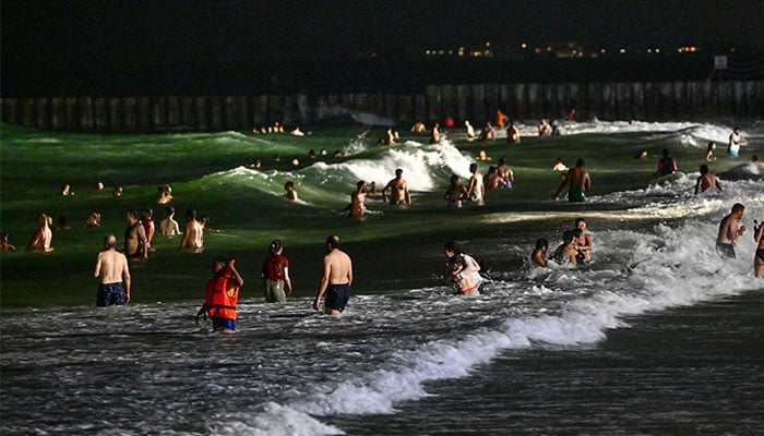 People gather at the Umm Suqeim beach in Dubai during the night of October 5, 2024. — AFP