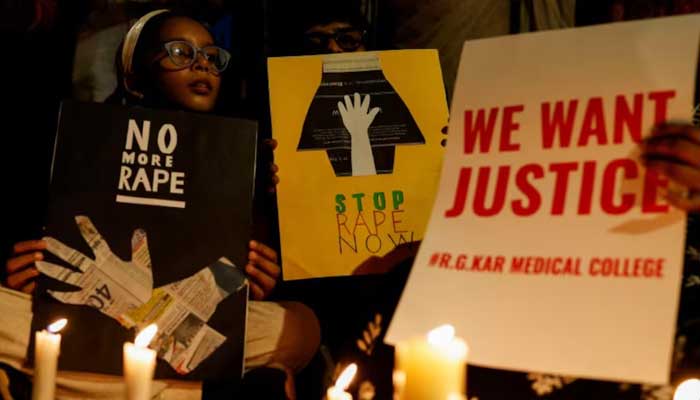 People hold posters during a vigil condemning the rape and murder of a trainee medic at a government-run hospital in Kolkata, on a street in Mumbai, India on August 14, 2024. — Reuters