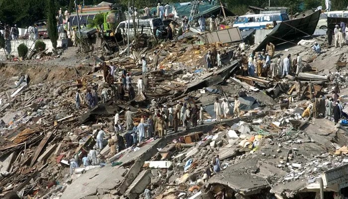 People walk over rubble in Balakot, Mansehra district in Khyber Pakhtunkhwa, on October 10, 2005, days after deadly 7.6 magnitude earthquake northeast Pakistan. — AFP