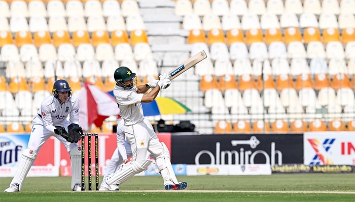 Pakistans Salman Ali Agha (R) plays a shot as Englands wicketkeeper Jamie Smith watches during the second day of the first Test cricket match between Pakistan and England at the Multan Cricket Stadium in Multan on October 8, 2024. — AFP