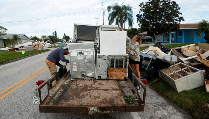 Contractors haul away debris left by Hurricane Helene along the roadside, as residents in New Port Richey prepare to evacuate ahead of the arrival of Hurricane Milton, Florida, October 8, 2024. — Reuters