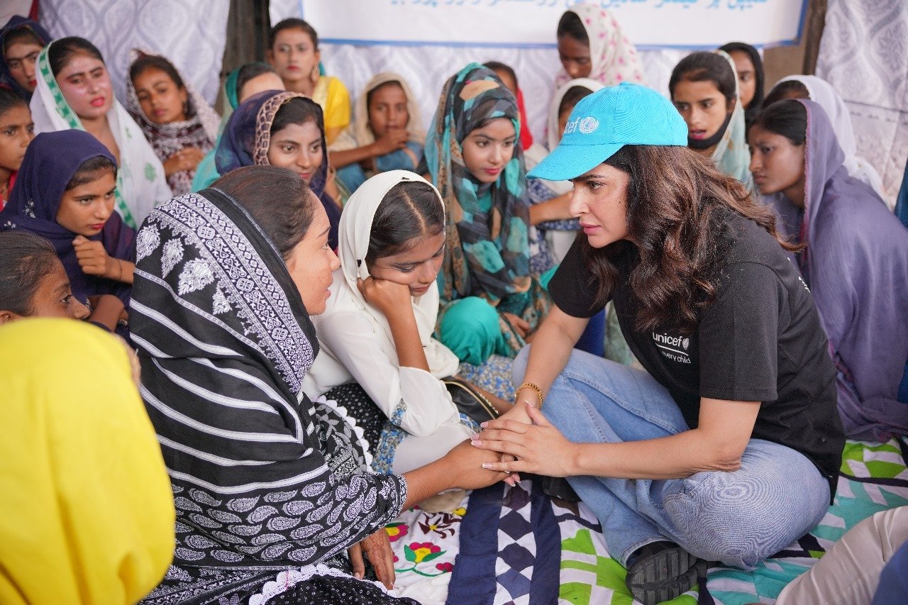 Actor Saba Qamar holds a womans hands as she intently listens to her during an engagement in a rural area. — Unicef