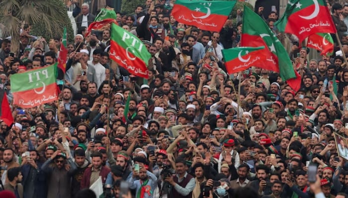 Supporters of former prime minister Imran Khans party wave flags as they protest in Peshawar on February 17, 2024. —Reuters