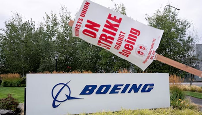 A strike sign hangs from a post near a Boeing sign as Boeing factory workers and supporters gather on a picket line during the third day of a strike near the entrance to a Boeing production facility in Renton, Washington, US September 15, 2024. — Reuters