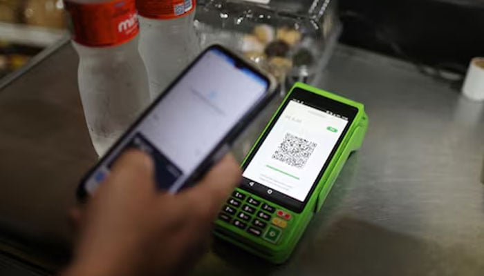 A person pays using their cell phone with the instant electronic payment mode known as PIX, at a store in Rio de Janeiro, Brazil April 1, 2024. — Reuters