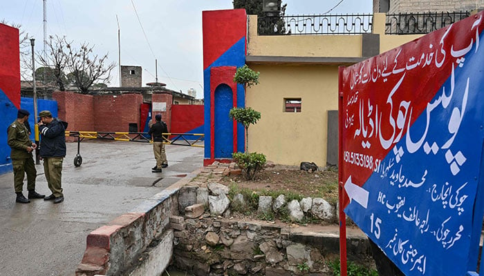 Police personnel stand guard near a signboard reading police check post Adiala at the entrance of Adiala jail on January 31, 2024. — AFP